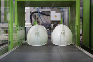 Helmet shells on conveyor belt